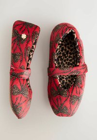 Piros szövet papucsok leopárd mintás belső résszel, fekete virágmintákkal a külsején, és elöl megkötős díszítéssel.