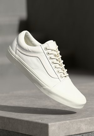 Hvit lær sneakers med en jevn tekstur, rund tå og flat gummisåle. Har fem snøringer og side stripe-detalj.