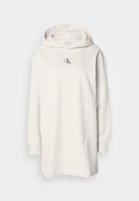Robe sweat à capuche longue couleur écrue, manches longues et petit logo « cK » sur la poitrine, présentée sur un fond uni.