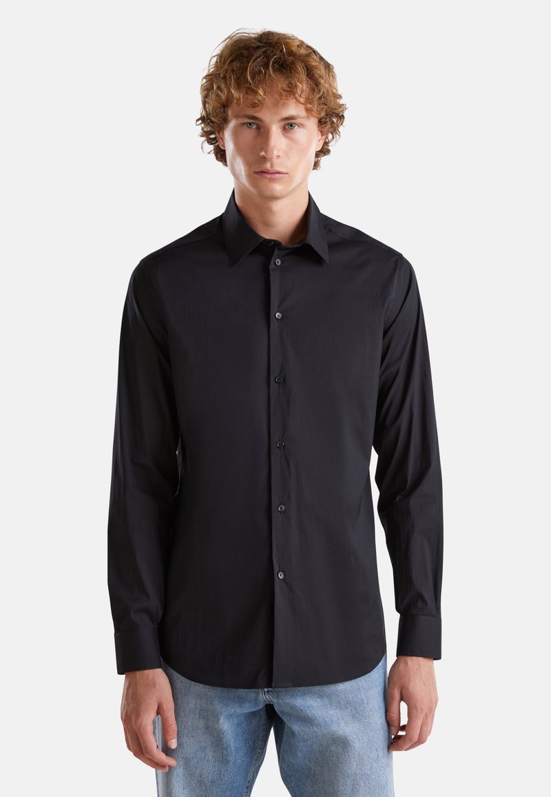 Camicia nera con bottoni, colletto strutturato, maniche lunghe e una trama liscia, dotata di bottoni neri e un design aderente.