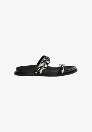 Flat black sandals with a smooth sole, featuring two straps in a zebra print pattern and a buckle detail on one strap.