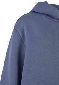 Felpa con cappuccio in morbido tessuto blu testurizzato con vestibilità rilassata. Presenta un grande cappuccio e maniche scese.