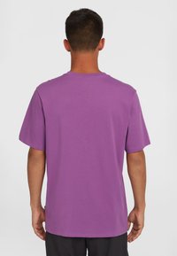 Purple t-shirt made of cotton with a relaxed fit, short sleeves, and a crew neckline; smooth texture with no visible patterns or accents.