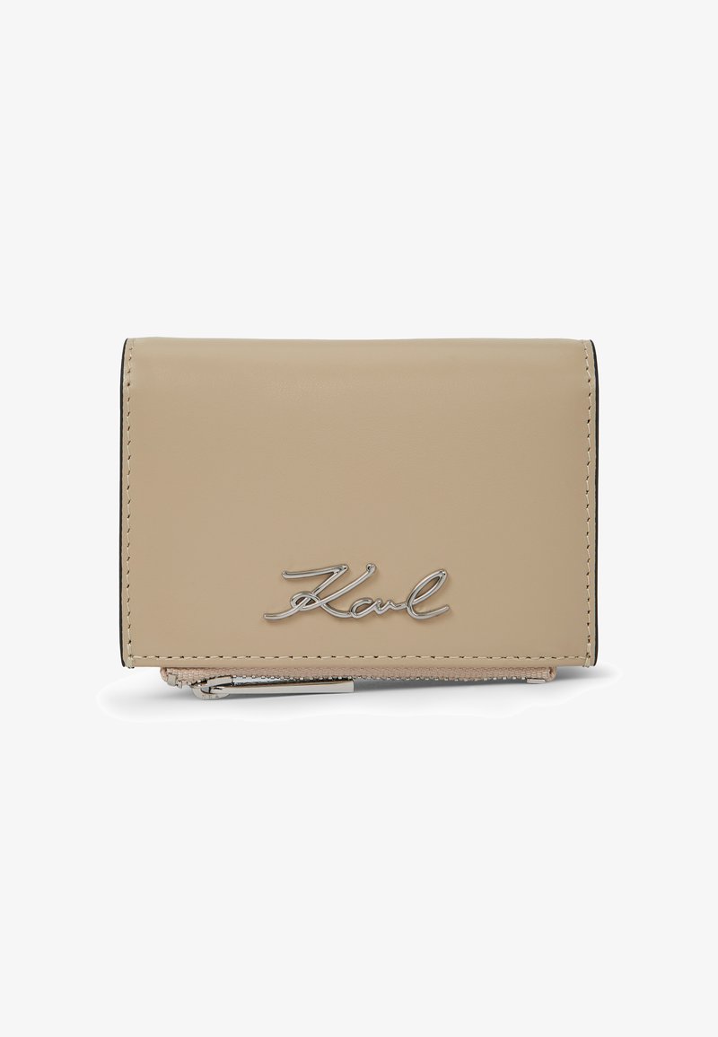 Μπεζ δερμάτινο πορτοφόλι με ασημί λογότυπο "Karl" στο μπροστινό μέρος και ορατό ασημί φερμουάρ στο κάτω άκρο.