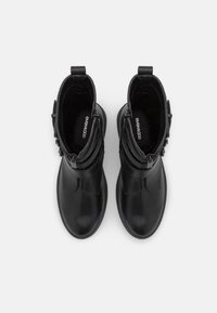 Bottes cheville noires en cuir lisse, bout arrondi, fermeture éclair latérale et doublure en tissu. Présentent un design minimaliste et une semelle en caoutchouc plate.