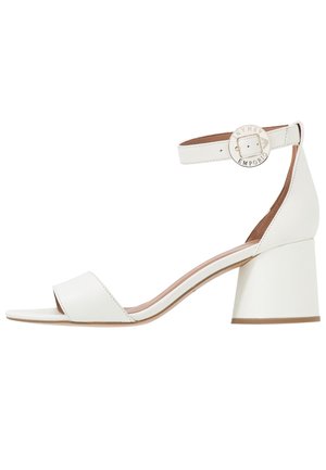 Valkoiset nahkaiset avokantaläskipohja sandaalit, joissa on nilkkahihna ja pyöreä kultainen solki, jossa on brändin kaiverrus.
