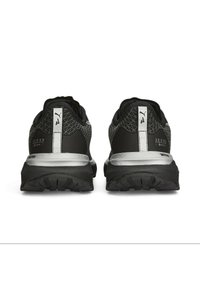 Zapatos deportivos negros con parte superior de malla texturizada, acentos plateados reflectantes y una suela de goma robusta con un patrón de relieve.
