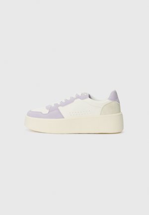 Hvit og lys lilla sneakers med en kraftig såle, suede- og lærmateriale, rund tå og minimal perforering på siden.