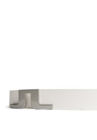 Vit läderbälte med en borstad metallspänne i en minimalistisk design, med en distinkt form och slät yta.