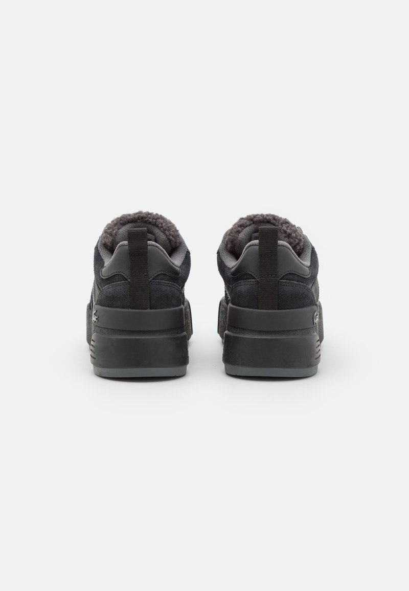 Baskets en suède noir avec un revêtement en laine grise texturée, une languette au talon et une semelle en caoutchouc noir résistante. Vue arrière.