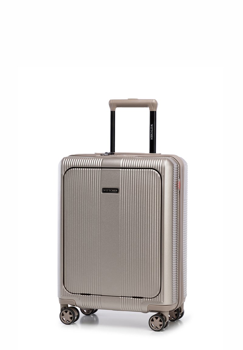 Steifer, goldener Koffer mit vertikalen Rillen, zwei glatten Rädern, einem ausziehbaren schwarzen Griff und einem Logo auf der Vorderseite.