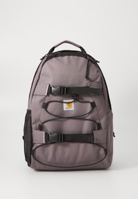 Gray backpack made of durable fabric, featuring black straps, mesh side pocket, and a front buckle closure. Carhartt logo displayed.