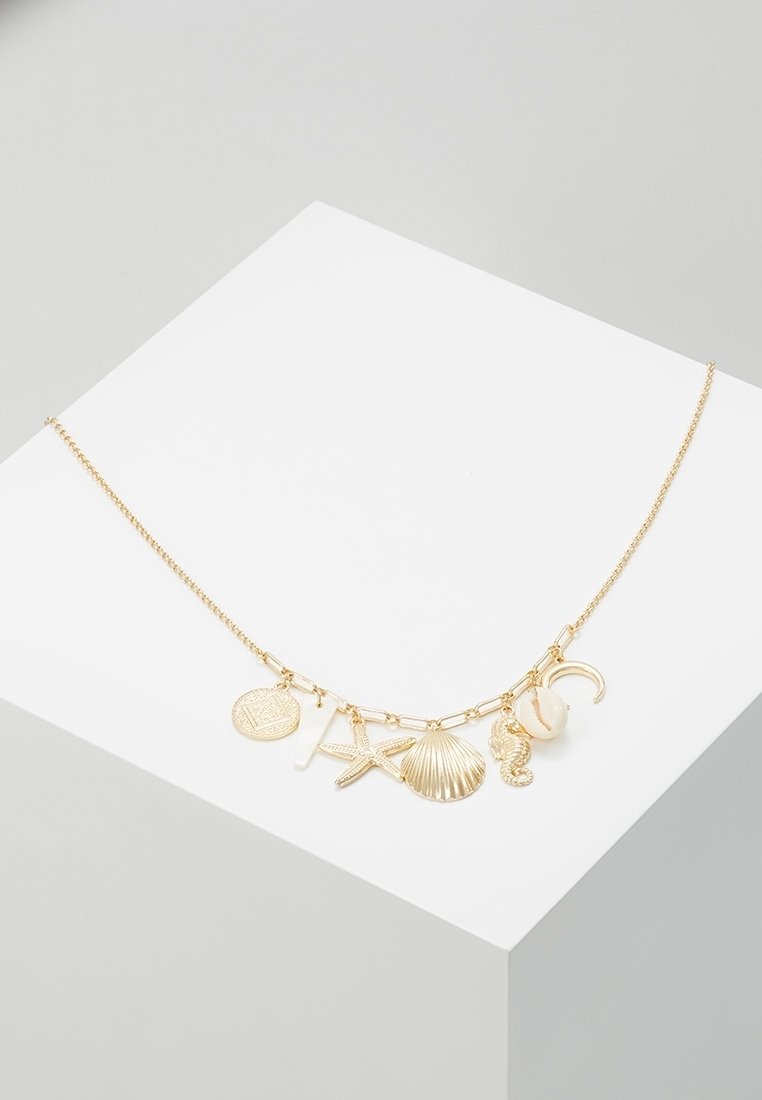 Collier chaîne en or avec des breloques sur le thème de la mer, comprenant une étoile de mer, un coquillage, un hippocampe, un croissant de lune et un pendentif rond avec des motifs.