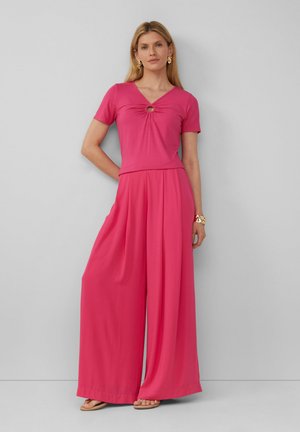 Ensemble rose en deux pièces comprenant un haut ajusté avec un décolleté en V et un détail noué, associé à un pantalon à jambes larges, le tout en tissu lisse.