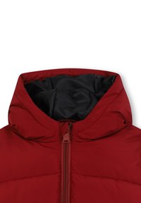 Czerwona ocieplana kurtka z wysokim kołnierzem, czarną podszewką i centralnym zapięciem na zamek. Tkanina wydaje się gładka, z minimalnymi detalami w szwach.