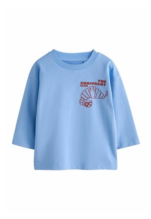 Hellblaues Langarmshirt mit rotem Grafikmotiv eines lächelnden Croissants, das einen karierten Becher hält, und dem Text „The Croissant Club“ auf der Brust.