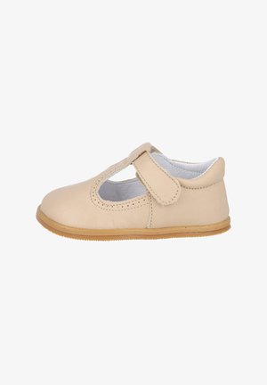Zapato tipo Mary Jane de cuero beige, con punta redondeada, tira de Velcro, detalle troquelado en la parte superior y suela de goma flexible.