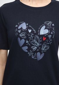 Μπλε ναυτικό T-shirt με σχέδιο καρδιάς από διάφορες μπλε καρδιές και χειρόγραφες επιγραφές, όπως "Tom Tailor loves you" και "je t'aime."