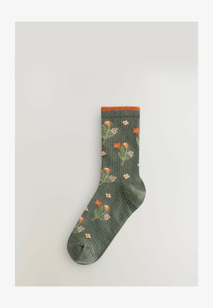 Grüne Socken mit einem gerippten Muster, verziert mit floralen Motiven in Orange und Weiß und einem orangen Bündchen. Strapazierfähiger Stoff für Komfort.