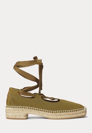 Espadrille plate vert olive avec semelle en jute tissée et liens en tissu à nouer autour de la cheville sur fond blanc.