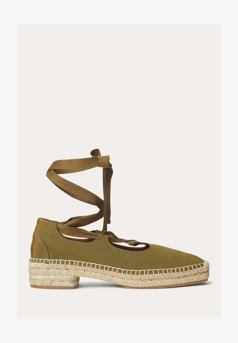 Λαδί επίπεδη επιστριγγί με πλεγμένη σόλα από τζούτ και υφασμάτινους δεσμούς που τυλίγονται γύρω από τον αστράγαλο σε λευκό φόντο.