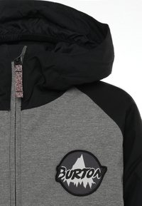 Burton Kapuzenjacke mit einem grau-schwarzen Farbschema, ausgestattet mit einem Logo-Patch, strukturiertem Stoff, Reißverschluss und elastischer Kapuze.