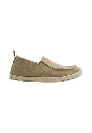 Zapato casual beige sin cordones con parte superior de tela texturizada, puntera redondeada, lengüeta en el talón y entresuela con patrón tejido.