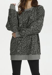 Felpa grigia con stampa leopardata, maniche lunghe, polsini e orlo a costine. Tessuto morbido, vestibilità rilassata e dettaglio del pattern distintivo.