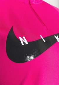 Fuchsia Sportbekleidung mit einem Viertel-Reißverschluss und glanzschwarzem Nike-Swoosh-Logo. Glatte Textur, eng anliegende Passform und minimalistisches Design.