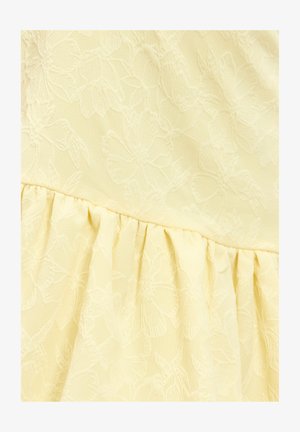 Geel stof met bloemenpatroon en zachte textuur, met een geplooid ruchesdetail aan de onderkant. Het geperste bloemenontwerp geeft diepte.