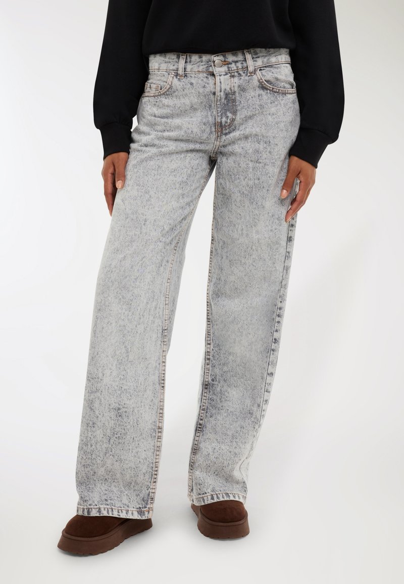 Jeans a gamba larga grigio chiaro con finitura scolorita, design a cinque tasche e chiusura con bottone. Tessuto denim morbido, dettagli di cucitura in contrasto.