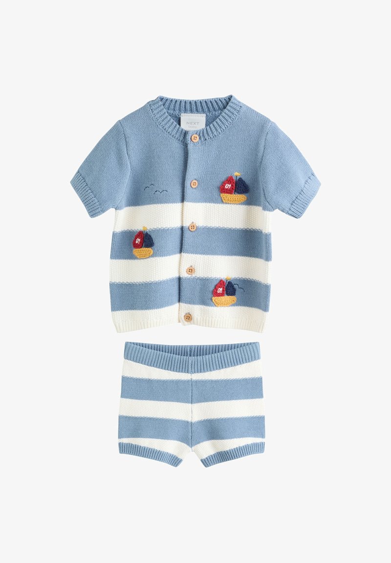 Ensemble tricoté bébé rayé bleu clair et blanc avec boutons, manches courtes, short, et bateaux à voile rouges et bleu marine brodés sur le haut.