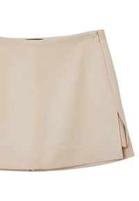 Gonna mini beige realizzata in tessuto liscio, con zip laterale e una leggera apertura per facilitare i movimenti. Design semplice ed elegante.