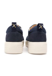 Granatowe zamszowe sneakersy z teksturowanym tyłem, białą gumową podeszwą oraz dekoracyjnym żółtym przeszyciem na pięcie i języku.