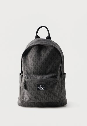 Sac à dos Calvin Klein gris foncé avec un motif répétitif "ck", poche avant zippée et poignée supérieure sur fond blanc.