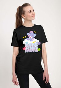 Camiseta negra con un oso de dibujos animados sobre una nube y el texto "CUIDADO BEARS PARA SIEMPRE" en colores divertidos. Manga corta, corte relajado.