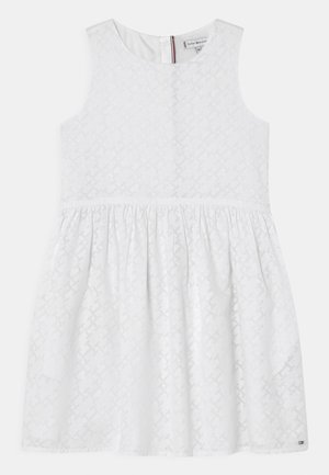 Biała sukienka o fakturowanym wzorze, bez rękawów, z okrągłym dekoltem i marszczoną spódnicą. Zapięcie z tyłu z subtelnym detalem z logo.