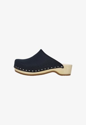 Sort perforeret slip-on træsko med sølvnitter langs kanten og en beige træsål og hæl.