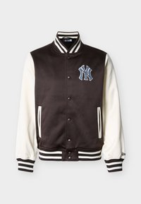 Μαύρο και άσπρο varsity μπουφάν με κουμπιά τύπου snap, ριγέ γιακά και μανσέτες, πλαϊνές τσέπες και λογότυπο των New York Yankees στο στήθος.