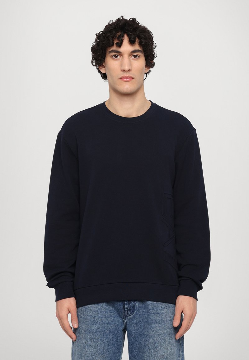 Sweatshirt azul-marinho com mangas longas, decote redondo e pormenores texturizados na parte da frente. Material suave e corte descontraído.