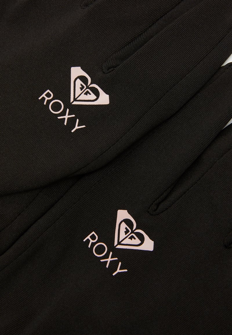 Guantes negros con textura acanalada, que presentan un diseño de logo blanco y un corazón. El material parece flexible, adecuado para actividades al aire libre.