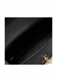 Interno di una borsa a tracolla in pelle nera con una texture liscia, dotata di una chiusura oro, foderato a righe e con più scomparti per un'ottima organizzazione.