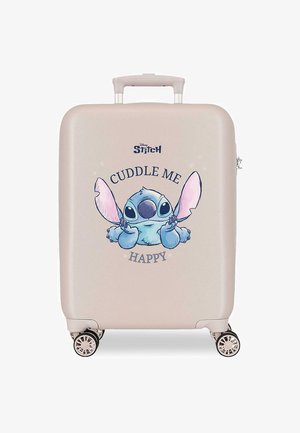 Maleta rígida beige con cuatro ruedas, con un personaje azul de dibujo animado Stitch y el texto "CUDDLE ME HAPPY" en el frente.
