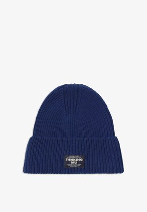 Blå ribbestrikket hue med omfoldet kant, prydet med en sort label med hvid tekst på den ene side. Blød tekstur, tætsiddende pasform og sømløst design.