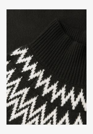 Suéter negro de punto con un alto cuello acanalado y un patrón de zigzag blanco en la parte frontal, con un acabado de textura suave.