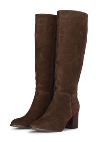 Bottes hautes en suède marron, avec un bout pointu et un talon empilé. Dotées d'une fermeture éclair sur le côté pour un enfilage facile. Texture douce et design épuré.