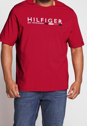 Rotes Baumwoll-T-Shirt mit dem Aufdruck "HILFIGER EST. MCMLXXXV" in Weiß und Marineblau. Kurzärmlig, Rundhalsausschnitt, legerer Schnitt.