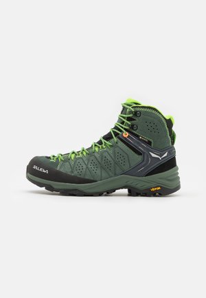 Grüner Wanderstiefel mit Obermaterial aus Wildleder und Mesh, kontrastierender schwarzer Gummikappe und leuchtend grünen Schnürsenkeln. Vibram-Laufsohle für optimale Traktion.