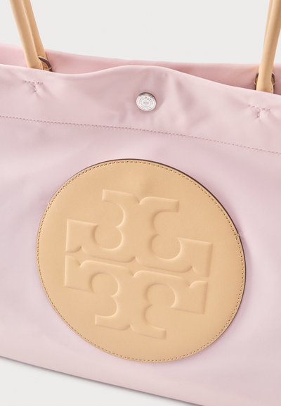 Ροζ τσάντα ώμου με ανάγλυφο λογότυπο σε μπεζ χρώμα σε σχήμα κύκλου και λουράκια σε καφέ απόχρωση με εμφανείς ραφές και μεταλλικό κούμπωμα με κουμπί.