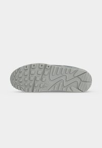 Γκρι σόλα αθλητικού παπουτσιού Nike με σχέδιο πέλματος και το λογότυπο Nike ανάγλυφο στο κέντρο σε λευκό φόντο.